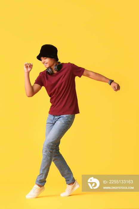 African-American teenager dancing against color background