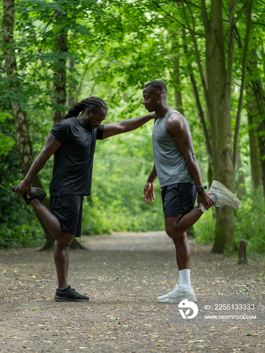 Two men stretching in forest