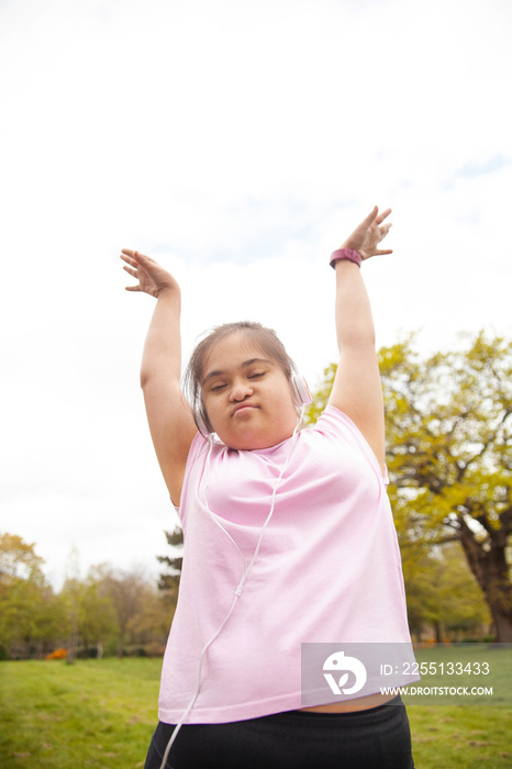 Young mid-sized woman with Down syndrome dancing outdoors