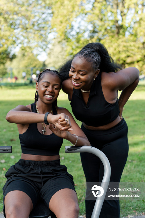 Young female friends exercising in outdoor gym