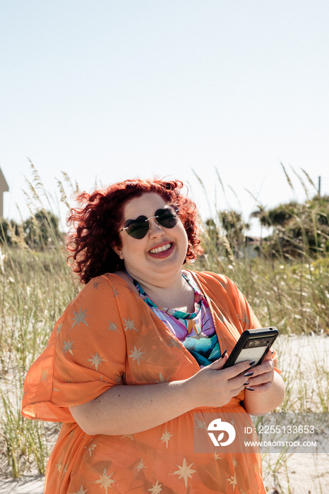 plus size woman laughs while holding phone