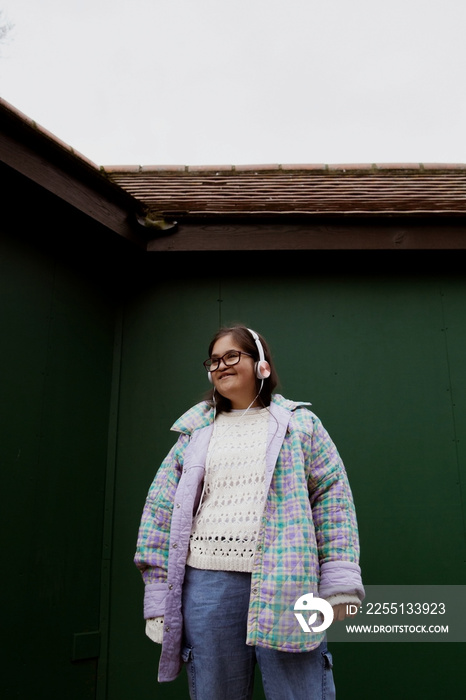 Young mid-sized woman with Down Syndrome dancing with headphones