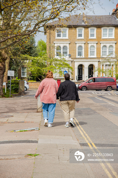 Lesbian couple walking holding hands.