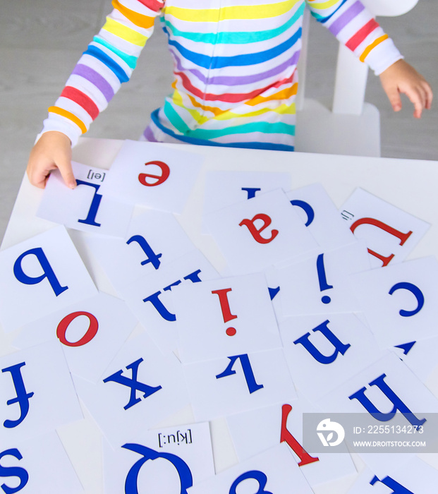 The child learns English letters. Selective focus.