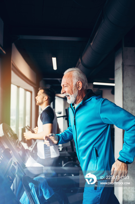 Senior and young sportsmen exercising at gym.