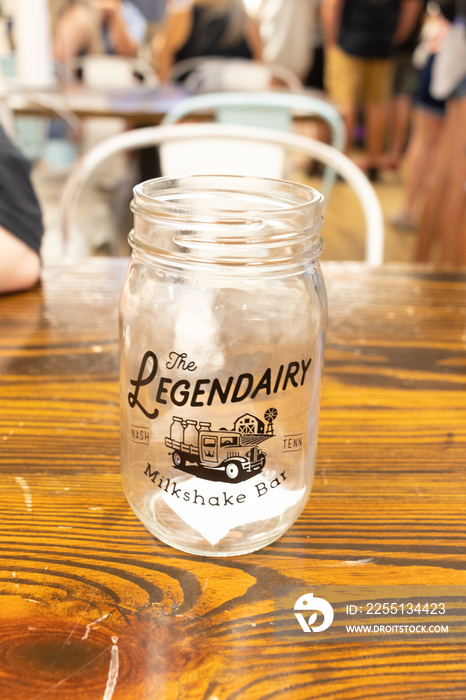 Empty mason jar which is a souvenir at Legendairy milkshake place in Nashville Tennessee. I love the wooden table it is sitting on and how the light seems to catch everything just right.