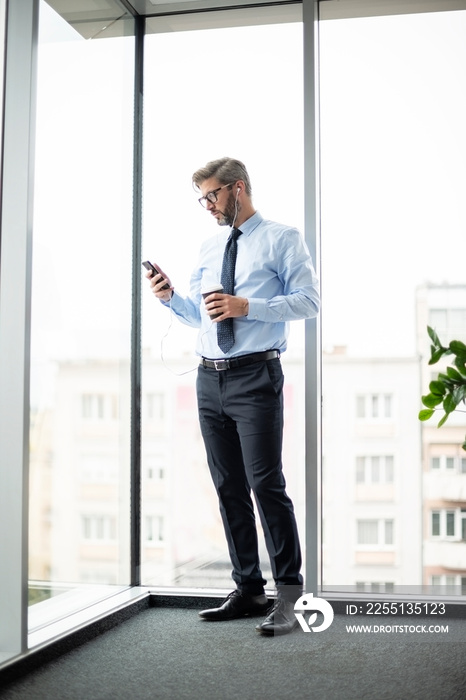 Middle aged  businessman using cell phone and text messaging