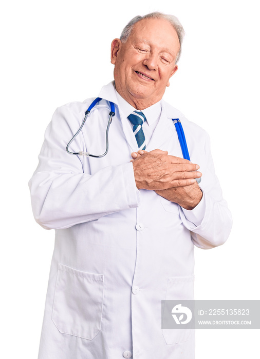 Senior handsome grey-haired man wearing doctor coat and stethoscope smiling with hands on chest with closed eyes and grateful gesture on face. health concept.