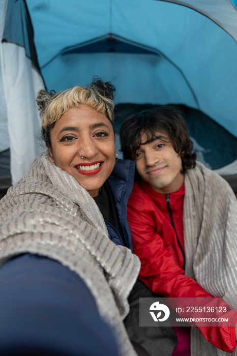 Portrait of mother and son sitting in tent