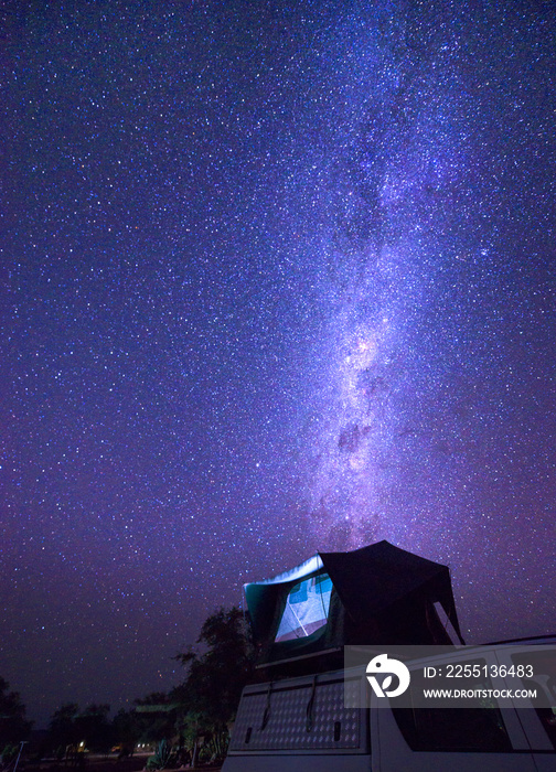 Milky way over a tent on the roof of a pickup car in the Namib desert of Namibia