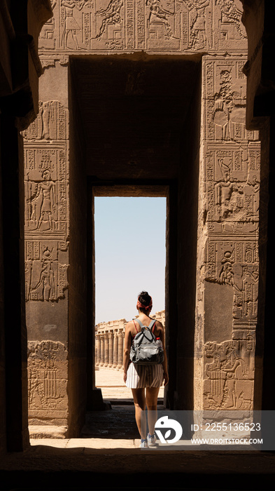 Woman walking to the entrance of an Egyptian temple