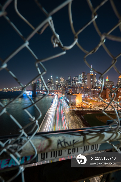 Image of New York City Night Cityscape with City View through a broken fence to see urban metropolis at night