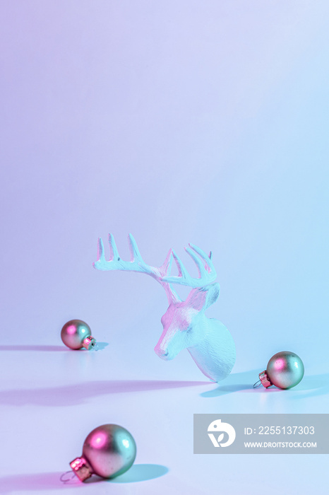 Christmas animal neon winter background. Holiday decoration bauble ball on neon gradient backdrop. Minimal abstract xmas reindeer. Happy new year copy space.