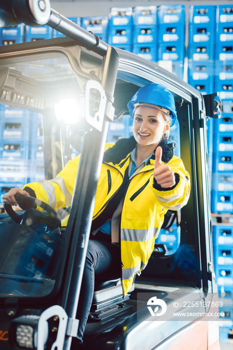 Worker woman showing thumbs up in logistics delivery center