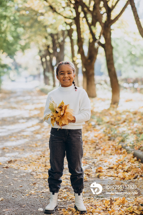 Cute little african girl in autumnal park