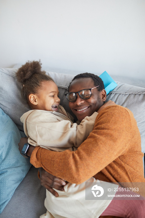 High angle portrait of happy African-American father embracing daughter after coming home from work on Fathers day