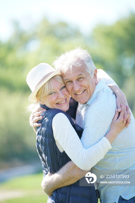 Cheerful senior couple embracing each other in countryside