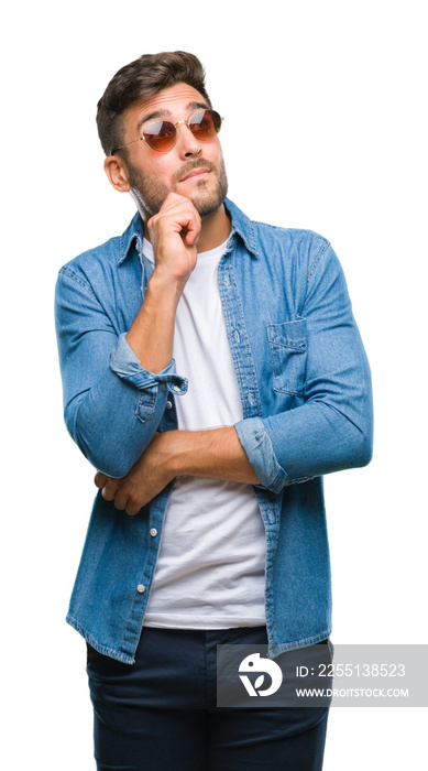 Young handsome man wearing sunglasses over isolated background with hand on chin thinking about question, pensive expression. Smiling with thoughtful face. Doubt concept.