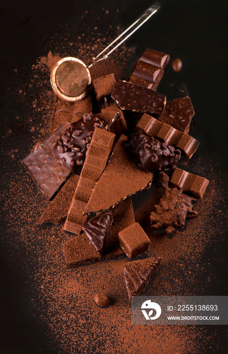 chocolate pieces and cocoa powder on wooden background