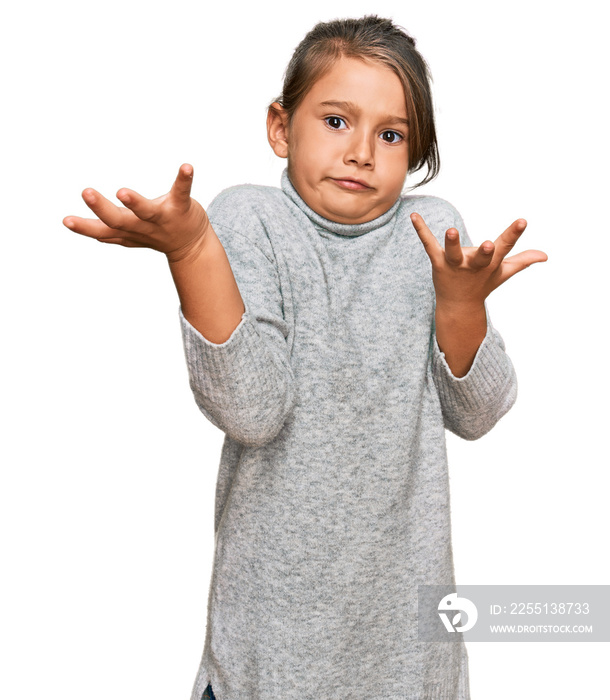 Little beautiful girl wearing casual turtleneck sweater clueless and confused expression with arms and hands raised. doubt concept.