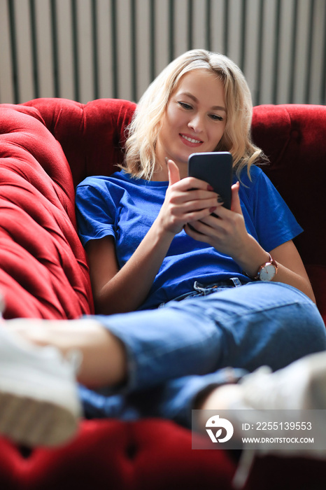 Young girl on a red sofa and relaxing