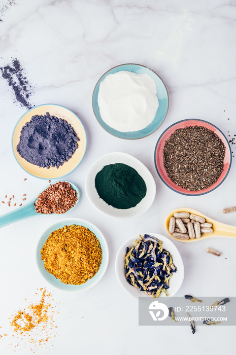 Variety of healthy food supplements such as blue matcha, butterfly pea flowers, collagen powder, spirulina powder, vitamins for vegans and vegetarians, flax and chia seeds,