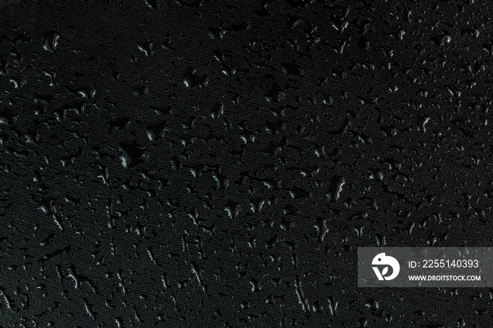 water drops on flat black rubber surface macro background