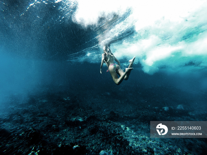 woman underwater playing with waves