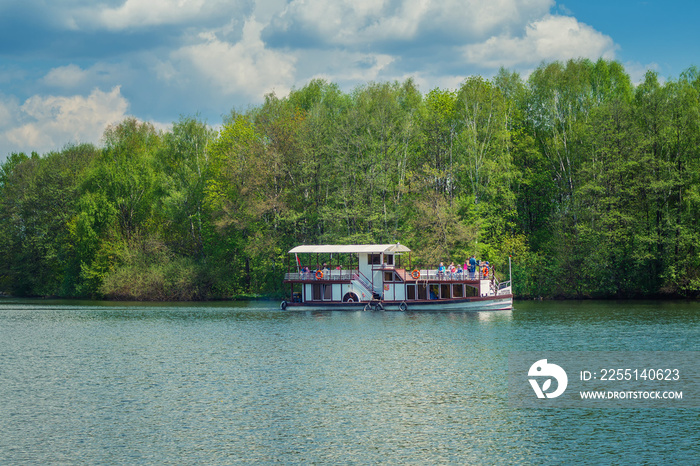 Tourist steamer on a river in the background of forest and green trees, concept of leisure, tourism and lifestyle with copy space