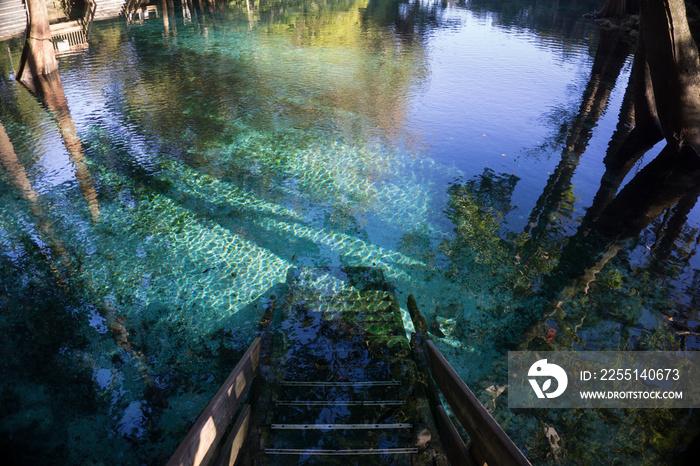 Wooden staircase steps going down to the crystal clear turquoise water of Ginnie Springs, Florida. In Santa Fe river