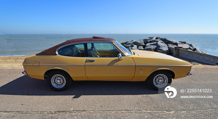 Classic Gold 2.0 Litre Ford Capri Ghia Motor Car Parked on Seafront Promenade.