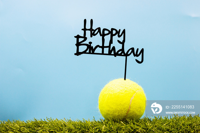 Tennis ball with Happy Birthday sign on white background