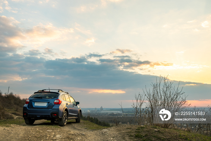 Landscape with blue off road car at sunset, Traveling by auto, adventure in wildlife, expedition or extreme travel on a SUV automobile. Offroad 4x4 vehicle in field at sunrise.