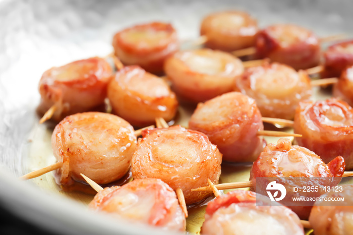 Frying pan with bacon wrapped scallops, closeup