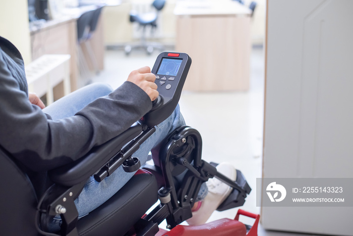 Close-up of a female hand on the control handle of an electric wheelchair