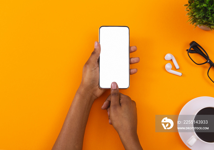 Black female hands holding and touching blank smartphone screen