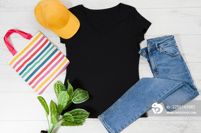 T shirt black. T-shirt Mockup flat lay with summer accessories. baseball hat, bag and denim jeans on wooden floor background. Copy space. Template blank canvas. Front top view.