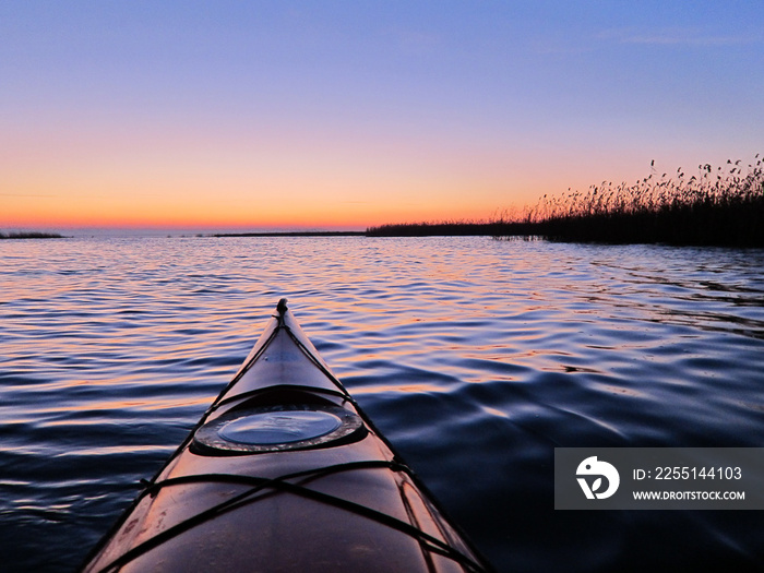 View of a red kayak at dusk. Purple evening on the lake