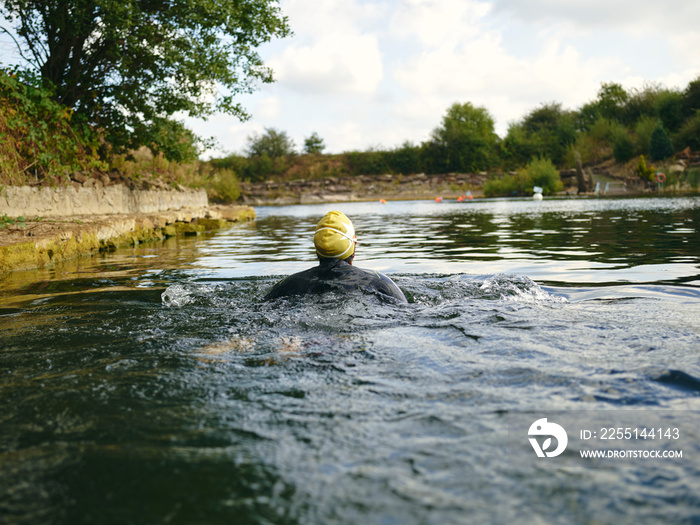 Woman in swimming cap swimming in river