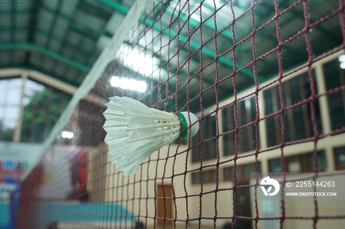 The shuttlecock hold on the badminton net in badminton court