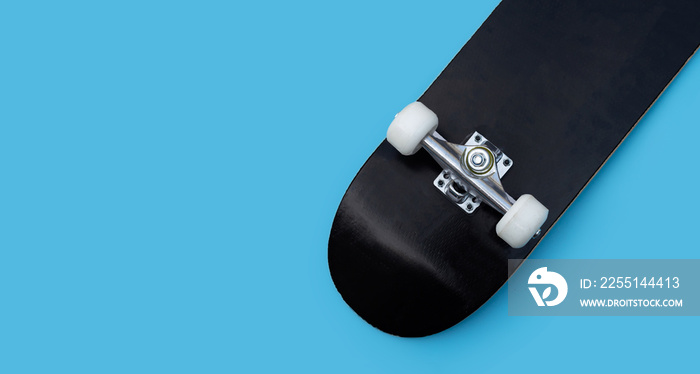 Black skateboard on blue background.