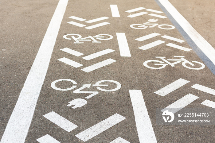 Asphalt road with bicycle and electric transport lane. Cycle and zero emission vehicles white sign on floor. Recreation area for green energy transport in city park