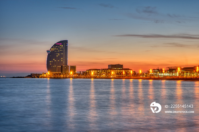 Barceloneta beach in Barcelona with the iconic skyscraper after sunset