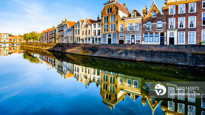 Sunset over a row of Houses that are reflecting on the water surface of a canal in the Historic City of Middelburg in Zeeland Province, the Netherlands