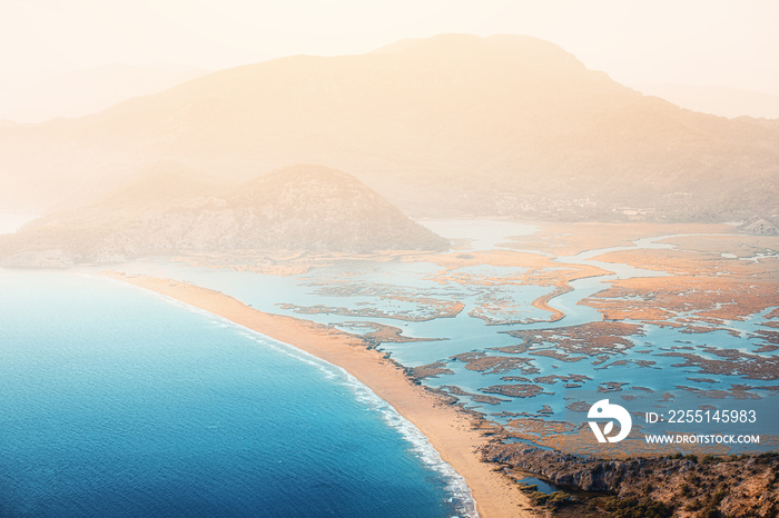 Scenic aerial paniramic view from mountain Bozburun to Iztuzu beach and the Dalyan river Delta as well as lake Sulungur at sunset time. Majestic autumn landscape. Explore natural wonders of Turkey