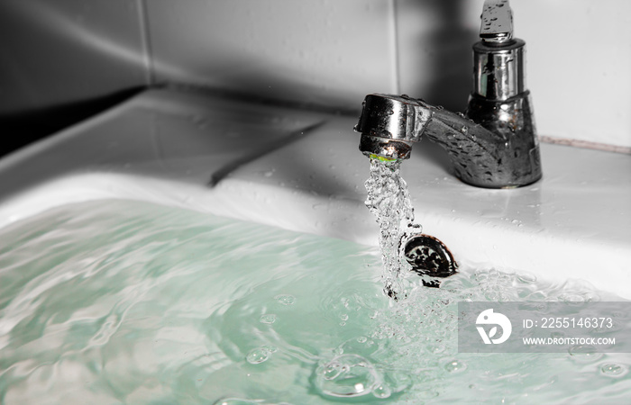 Faucet or tap and water flow pouring in bathroom .