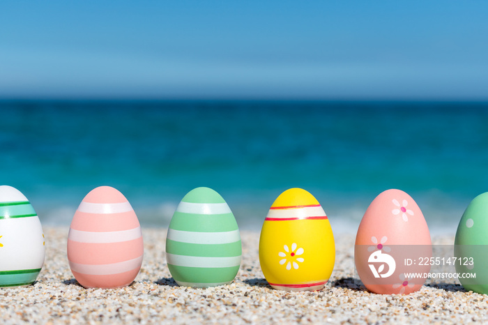 Colorful Easter eggs on the beach in sunny day. Easter concept.