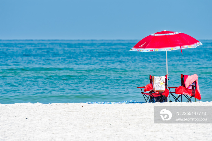 Beach umbrella, chairs, white sand and aquamarine water