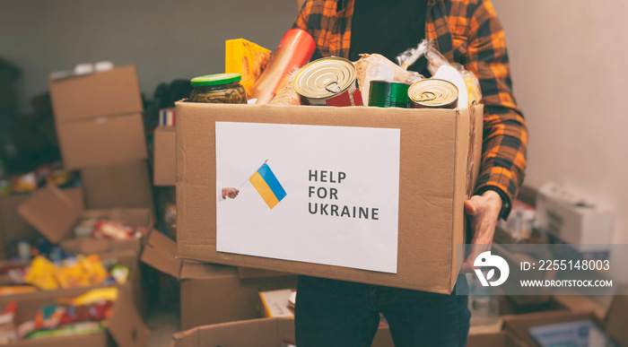 The volunteer packing the bag with groceries and necessary things for people in need