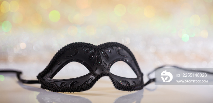 Black carnival mask on bokeh background